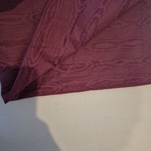 Rich burgundy fabric with design.